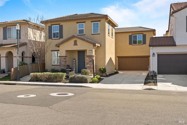 view of front of house with driveway, stucco siding, a tile roof, and a garage