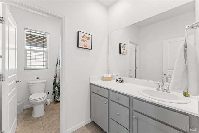 bathroom with tile patterned flooring, vanity, baseboards, and toilet