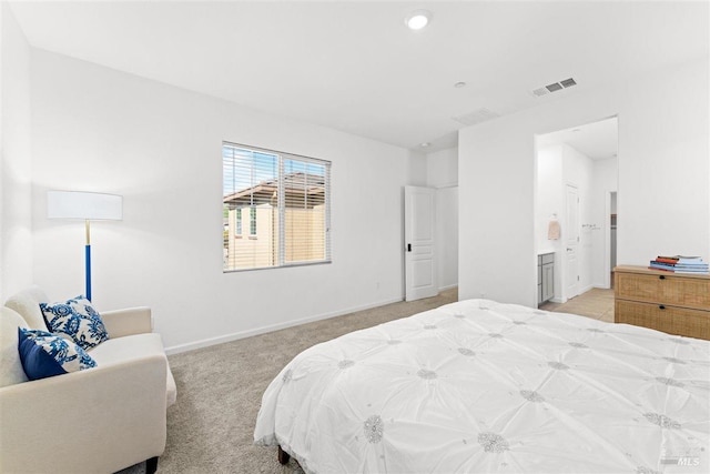bedroom featuring visible vents, baseboards, recessed lighting, ensuite bath, and light colored carpet