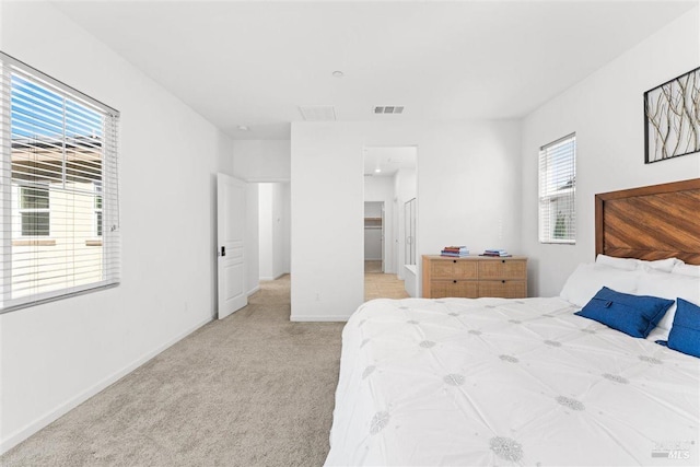 bedroom featuring light colored carpet, baseboards, and visible vents