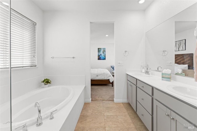 bathroom featuring a bath, double vanity, ensuite bathroom, and a sink