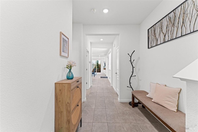 hallway featuring light tile patterned floors, baseboards, and recessed lighting
