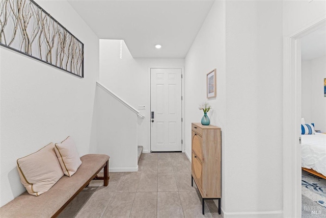 foyer entrance featuring light tile patterned floors, baseboards, stairway, and recessed lighting