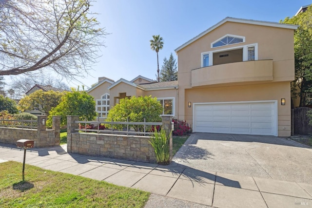 view of front facade with concrete driveway, an attached garage, fence, and stucco siding