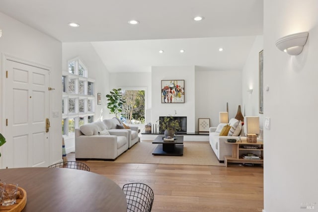 living room featuring lofted ceiling, light wood finished floors, and recessed lighting