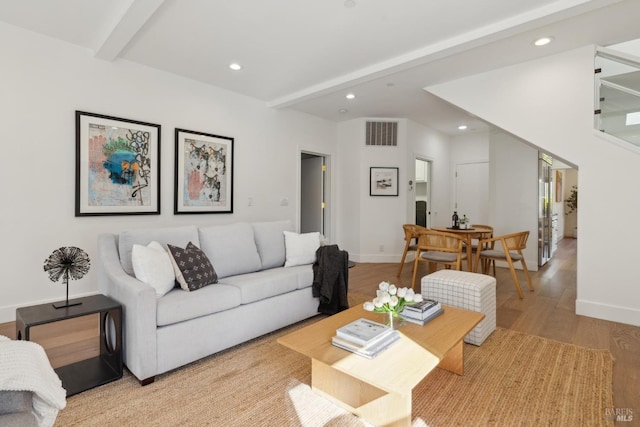 living room with beam ceiling, wood finished floors, visible vents, and recessed lighting