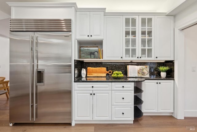 kitchen featuring tasteful backsplash, stainless steel built in fridge, and white cabinetry