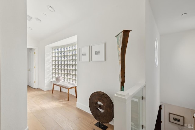 hallway featuring light wood-type flooring and baseboards