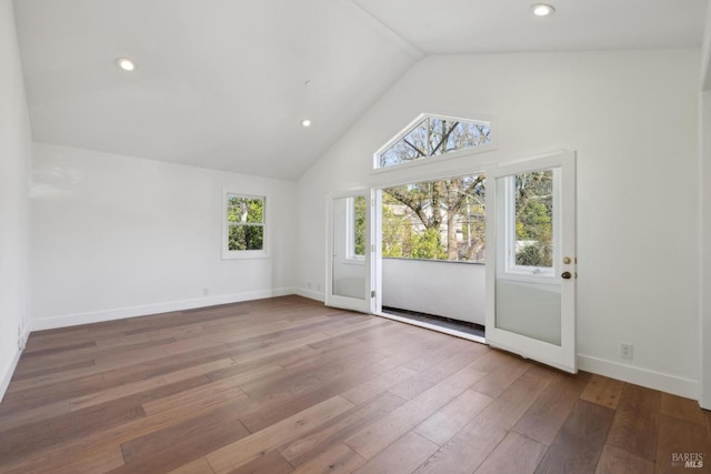 unfurnished room featuring high vaulted ceiling, recessed lighting, wood finished floors, and baseboards