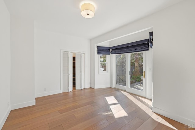 unfurnished room featuring wood-type flooring and baseboards