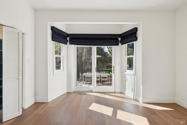 entryway with plenty of natural light, baseboards, and wood finished floors