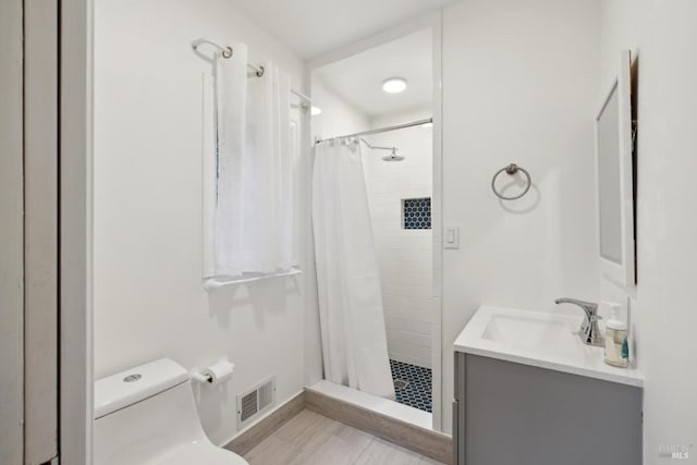 full bath with visible vents, vanity, a shower stall, and toilet