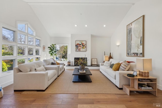 living room featuring high vaulted ceiling, recessed lighting, wood-type flooring, and baseboards