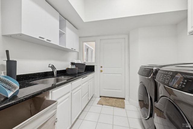 laundry area with cabinet space, light tile patterned flooring, a sink, and washing machine and clothes dryer