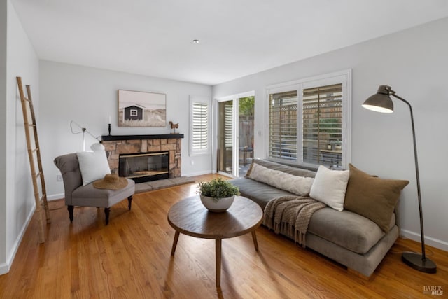 living area with wood finished floors, baseboards, and a fireplace