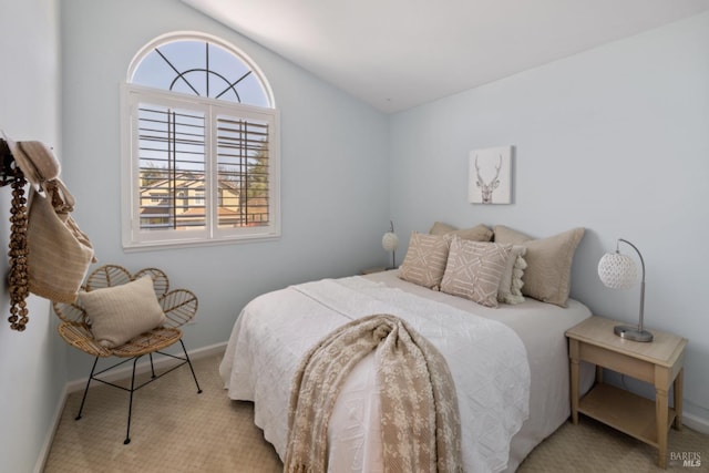 carpeted bedroom featuring vaulted ceiling and baseboards