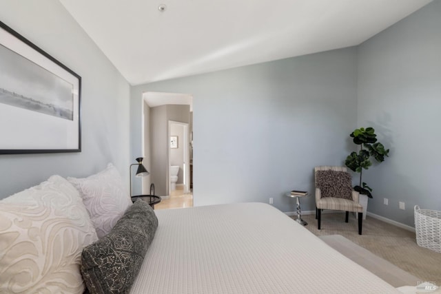 bedroom featuring lofted ceiling, light colored carpet, and baseboards