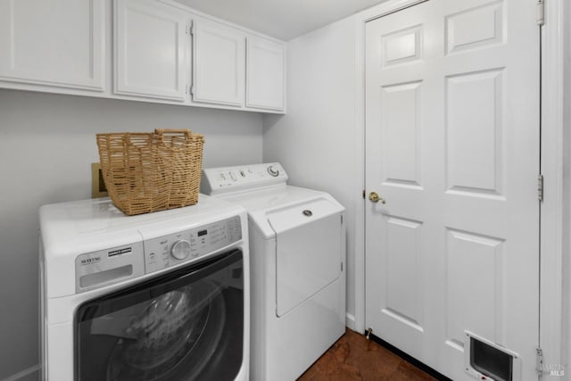 laundry room with visible vents, washing machine and dryer, and cabinet space