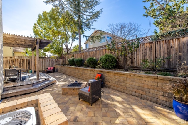 view of patio featuring a pergola, a fenced backyard, an outdoor fire pit, and a deck