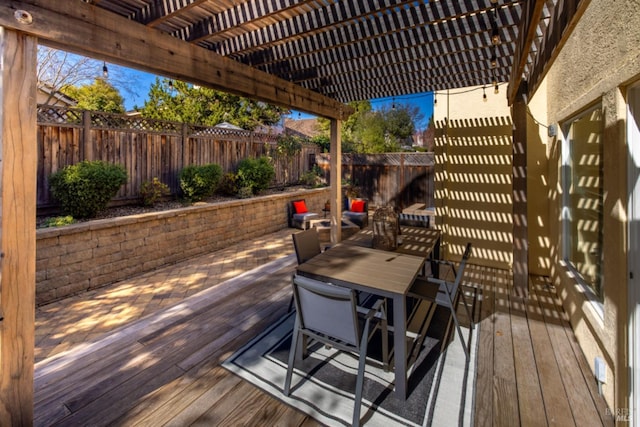 deck with outdoor dining space, a fenced backyard, and a pergola