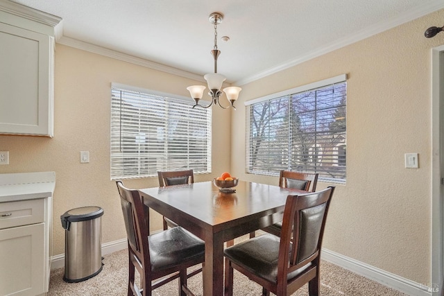 dining area with a notable chandelier, crown molding, baseboards, and a textured wall