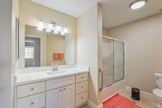 full bathroom with tile patterned floors, toilet, shower / bath combination with glass door, baseboards, and vanity