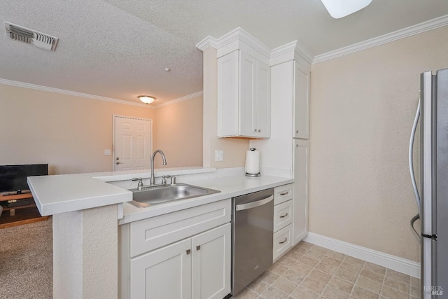 kitchen featuring visible vents, appliances with stainless steel finishes, a peninsula, white cabinetry, and a sink