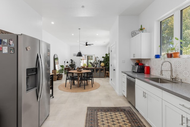 kitchen with stainless steel appliances, recessed lighting, tasteful backsplash, white cabinetry, and a sink