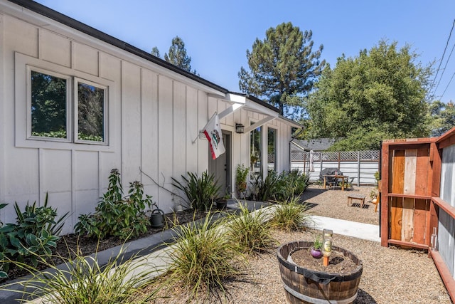 exterior space with board and batten siding and fence