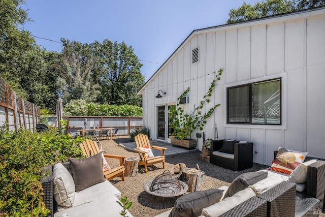 view of patio / terrace with fence and an outdoor living space with a fire pit