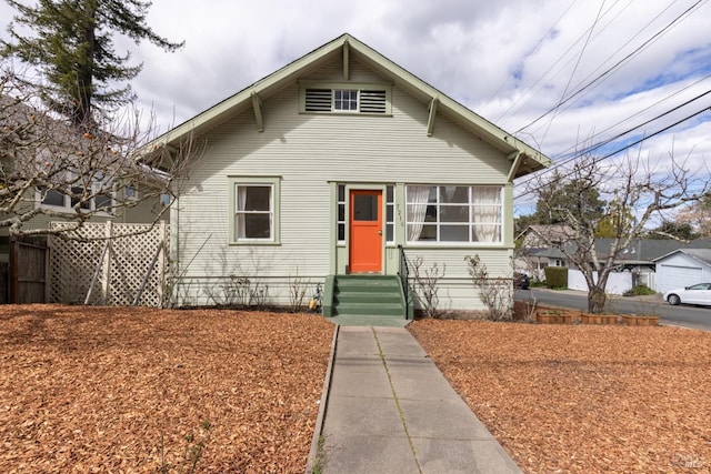 bungalow-style home featuring entry steps and fence