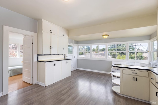 kitchen with wood finished floors, baseboards, white cabinets, open shelves, and tasteful backsplash