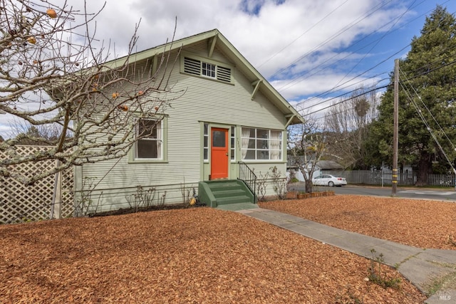 bungalow-style home featuring entry steps and fence