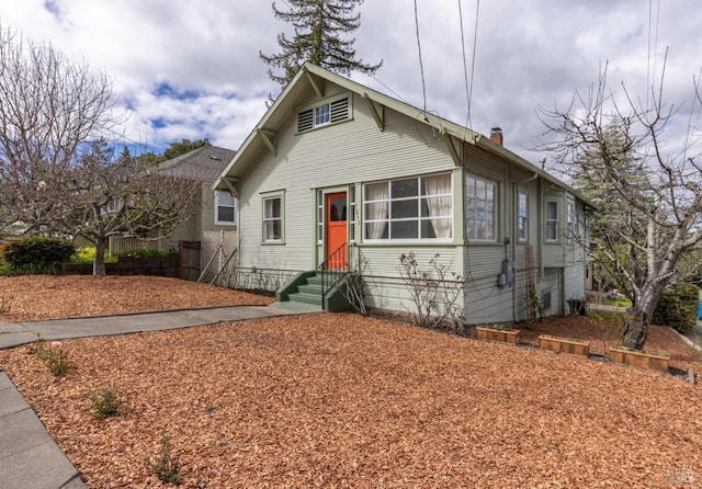 bungalow-style home with entry steps and a chimney