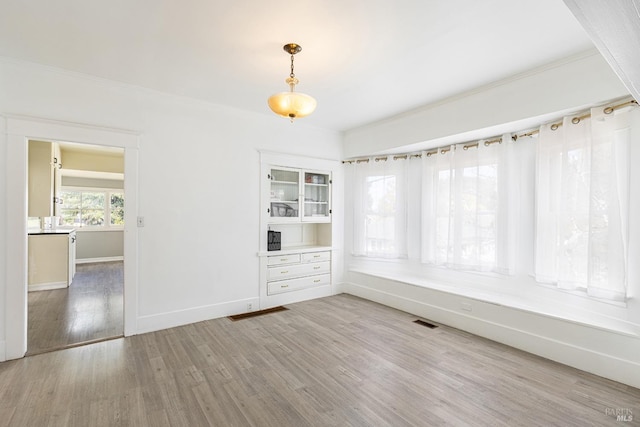 interior space featuring baseboards, visible vents, and wood finished floors