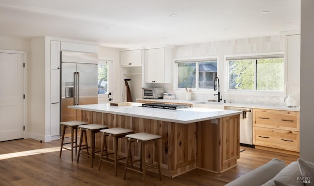 kitchen featuring stainless steel appliances, plenty of natural light, a sink, and a kitchen island