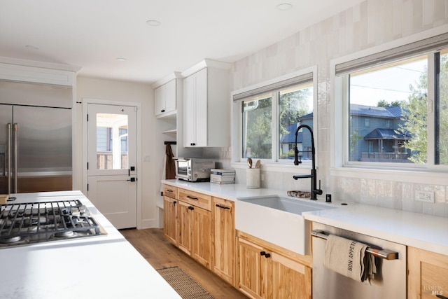 kitchen with stainless steel appliances, a toaster, light countertops, and a sink