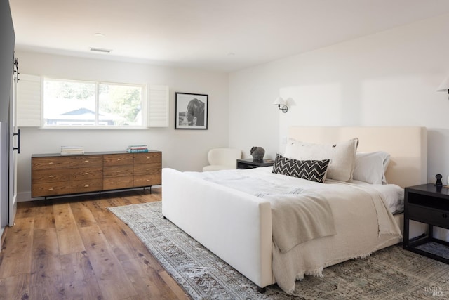 bedroom with light wood-style floors and visible vents