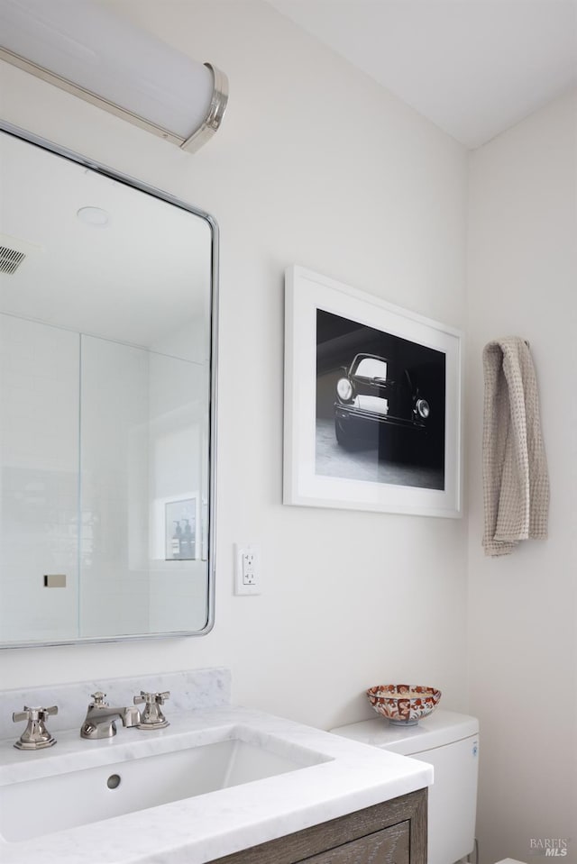 bathroom featuring vanity and toilet