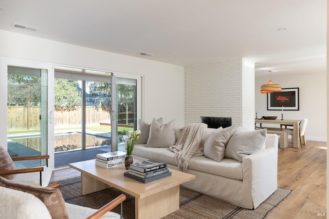 living area with baseboards, visible vents, and light wood finished floors