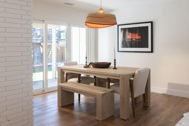 dining area featuring a healthy amount of sunlight, visible vents, and wood finished floors