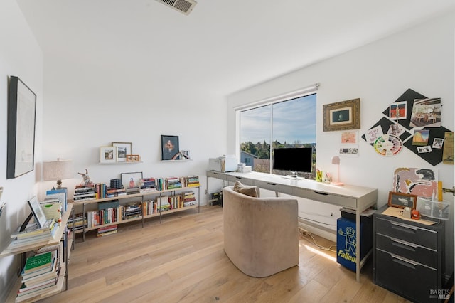 home office with light wood finished floors and visible vents