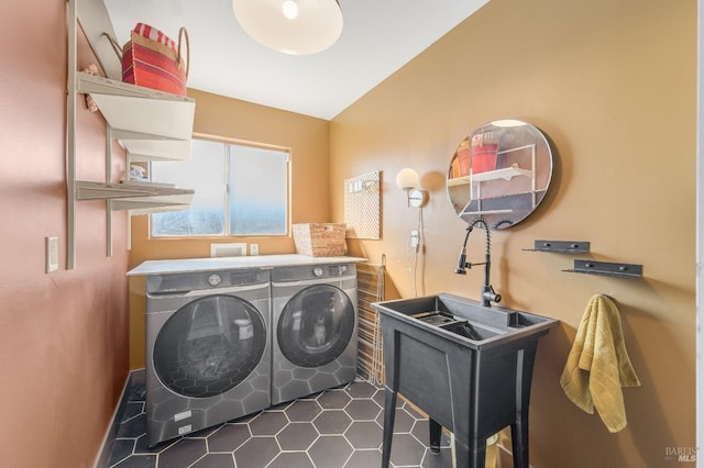 clothes washing area featuring laundry area, a sink, and washer and clothes dryer