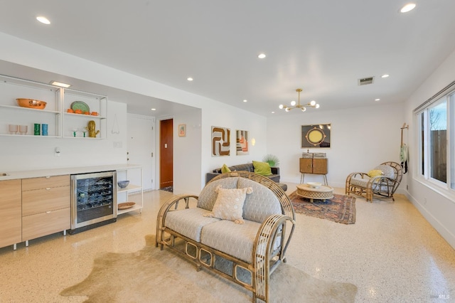 living room with light speckled floor, recessed lighting, visible vents, a chandelier, and beverage cooler