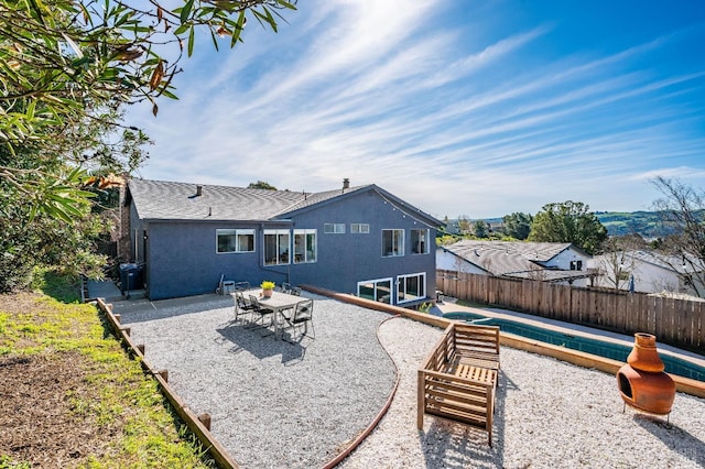 back of house with a patio area, fence, and stucco siding