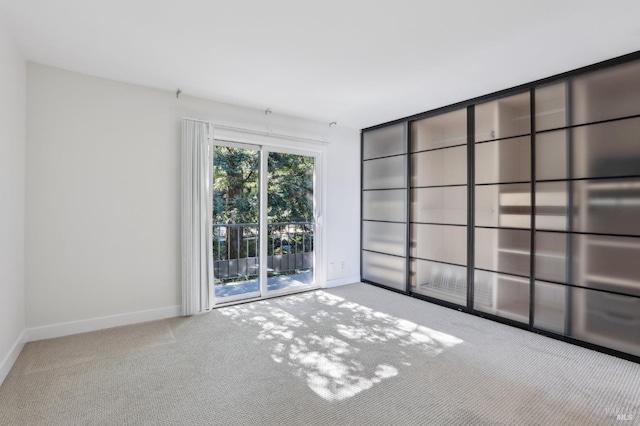 empty room featuring carpet floors and baseboards