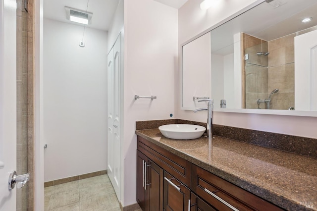 bathroom with a shower stall, visible vents, baseboards, and vanity