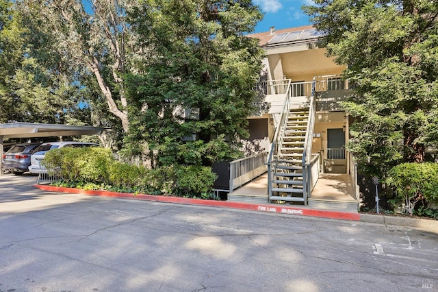 view of property with stairs and covered parking