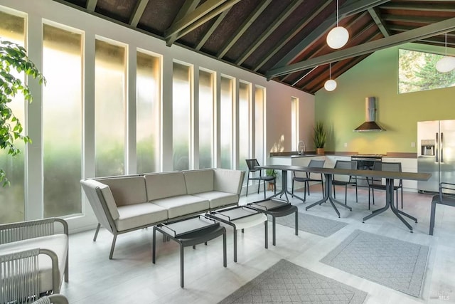 interior space with lofted ceiling with beams, a sink, and a wealth of natural light