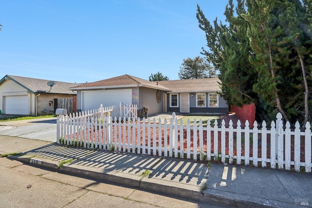 single story home featuring a fenced front yard, concrete driveway, and a garage